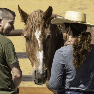 A man listens to his instructor as she guides him through an Equine Assisted Learning session at the National Ability Center.