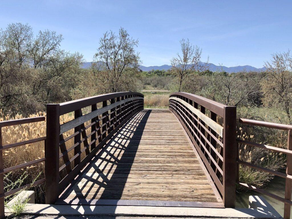 A wooden walking bridge goes over a river. 