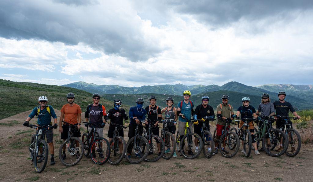A group of veterans on mountain bikes pose for a group photo. 