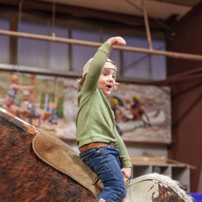 Kid riding a mechanical bull at Barn Party